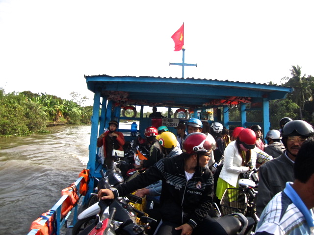 Rustic ferries transporting locals on motorbikes to the other side of the Mekong Delta