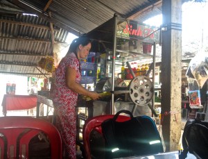 A South Vietnamese woman making sugar cane juice with a manual press