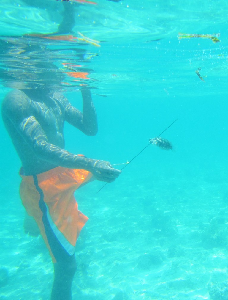 Our guide catching a fish while spearfishing off the coast of Cebu