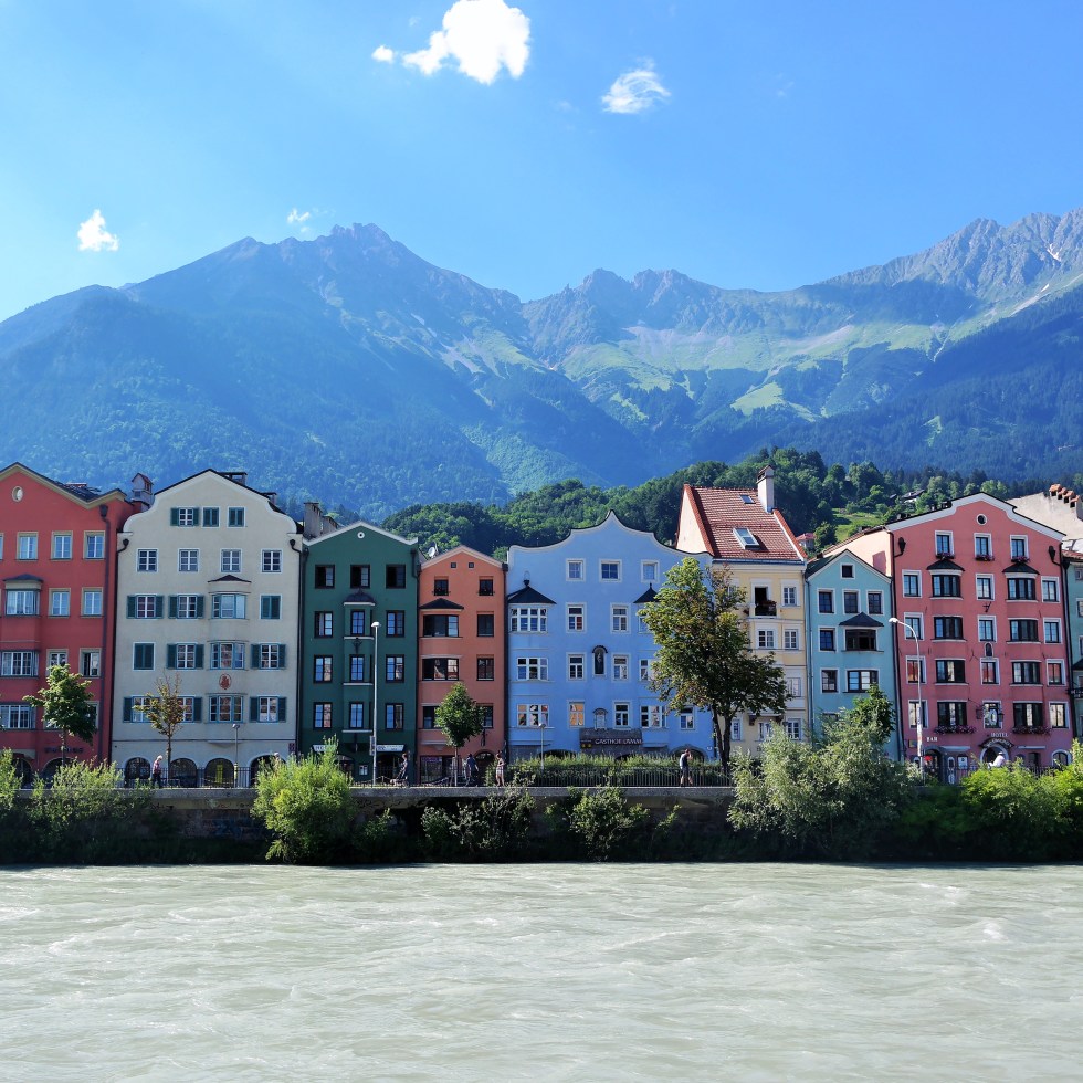 View of colorful homes and buildings along the Inn River in Innsbruck, Austria