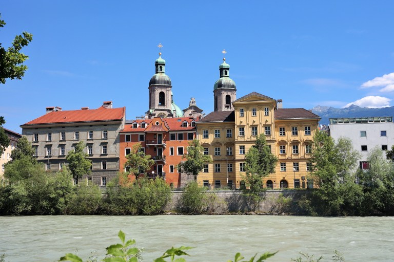 View of the colorful buildings and church along the Inn River in Innsbruck, Austria